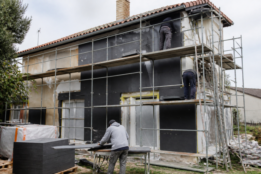 Maison française en rénovation énergétique avec artisans au travail