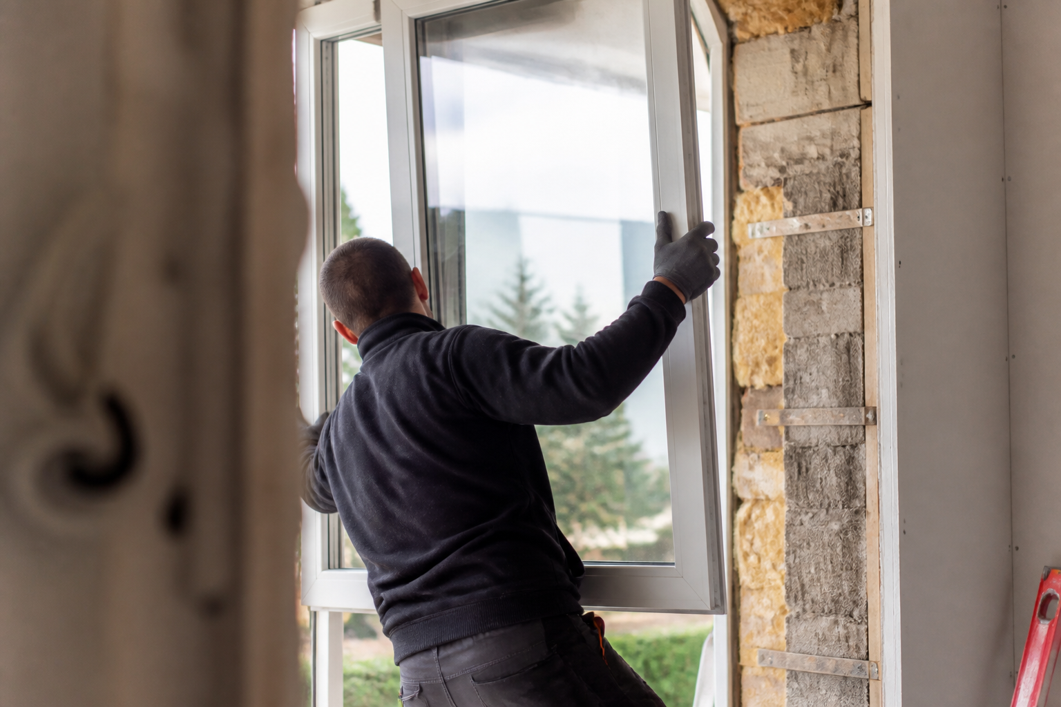 Artisan en train de poser une fenêtre double vitrage certifiée RGE